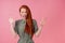 Redhair ginger woman amazed and surprised in cotton green white peas dress in pick background studio