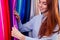 Redhair ginger woman choosing color textile in tailor shop for new cloth sewing.she determines the colors that best suit