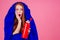 Redhair ginger woman holding red thermos and wrapped in in sleeping bag