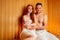 Redhaired ginger woman and her boyfriend steaming in the bathhouse with russian bunch broom.couple in love enjoying the