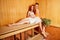 Redhaired ginger woman and her boyfriend steaming in the bathhouse with russian bunch broom.couple in love enjoying the