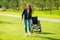 Redhaired ginger woman making first steps after long recovery.she walking without her wheelchair in spring park