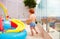 Redhead baby boy having fun running around inflatable kid pool a