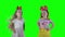 Redhead and blond little girls jumping in front of camera. green background.