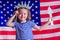 Redhead blonde charming female kid celebration independence holding a paper torch and diy crown and american flag on a
