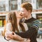 The redhead boy looks tenderly at girl and kiss. Concept of teenage love and first kiss, love, relationship, couple. City,