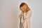 Redhead caucasian business woman standing over isolated background with sad expression covering face with hands while crying