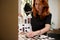 Redhead European pretty woman, professional mid adult hairdresser in barbershop , hairdressing salon, wearing stylish black