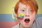 Redhead fan boy with ecuadorian flag painted on his face