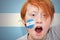 Redhead fan boy with nicaraguan flag painted on his face