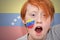 Redhead fan boy with venezuelan flag painted on his face