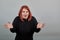 Redhead fat lady in black sweater surprised woman reacts, hands spread wide