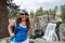 Redhead female hiker wearing a ballcap poses at Rainbow Falls in California along the John Muir Trail