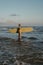 Redhead female surfer with a surfboard in the ocean