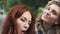Redhead friends taking selfie with a smart phone and making faces and fun.