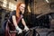 Redhead ginger woman blacksmith portrait in workshop