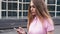 Redhead ginger woman using mobile phone during walk on streets of city