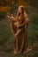 Redhead girl with deer in a long dress