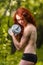 Redhead girl exercising with dumbbells at forest