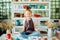 Redhead girl sitting at clay workshop studio with many cup