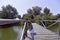 Redhead girl staying on a wooden dock above Danube river near trees.