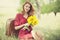 Redhead girl with sunflower at outdoor.