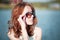 Redhead girl in sunglasses. close-up. emotions. Young redhead girl relaxing in sunglasses. woman relaxing outdoors. sinking eyes