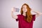 Redhead girl takes a selfie. She has long red hair. wears marsala t-shirt