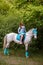 Redhead girl and white horse in the forest