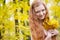 Redhead girl with yellow autumn leaves