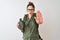 Redhead hiker woman wearing backpack holding canteen over isolated white background with open hand doing stop sign with serious