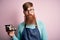 Redhead Irish cook man with beard holding maki sushi tray over isolated background with a confident expression on smart face