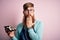 Redhead Irish cook man with beard holding maki sushi tray over isolated background cover mouth with hand shocked with shame for