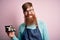 Redhead Irish cook man with beard holding maki sushi tray over isolated background with a happy face standing and smiling with a