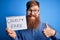 Redhead Irish man with beard holding cruelty free vegan cosmetics message over blue background happy with big smile doing ok sign,