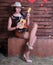 Redhead legged photomodel in minidress and  stockings with guitar  posing in studio