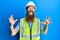 Redhead man with long beard wearing safety helmet and reflective jacket crazy and mad shouting and yelling with aggressive