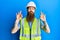 Redhead man with long beard wearing safety helmet and reflective jacket relax and smiling with eyes closed doing meditation