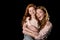Redhead mother and daughter having fun together isolated on black