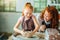 Redhead mother and her child daughter moulding with clay on pottery wheel