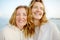 Redhead senior mother and her beautiful adult daughter are walking together and laughing