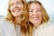 Redhead senior mother and her beautiful adult daughter are walking together and laughing