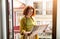 Redhead senior woman checking travel map while standing alone on home balcony