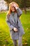 Redhead smiling pretty woman walking in park on sunny autumn day. Elegant female poses in stylish authentic outfit has