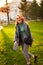 Redhead smiling pretty woman walking in park on sunny autumn day. Elegant female poses in stylish authentic outfit has