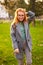 Redhead smiling pretty woman walking in park on sunny autumn day. Elegant female poses in stylish authentic outfit has