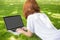 Redhead using laptop in the park