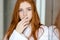 Redhead woman in bathrobe looking at camera