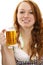 Redhead woman in bavarian dress and a glass with b