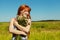 Redhead woman with a bouquet of flowers in a dress outdoors. stylish romantic young girl in field